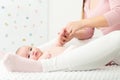 Baby massage background. Mother gently massaging her baby boy. Baby lying on back and looking at camera during massage.