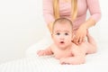 Baby massage background. Young therapist giving a baby boy a back massage.