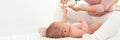 Baby massage banner with copy space. Kids therapist applying massage oil to baby boy. Mother massaging her newborn baby. Royalty Free Stock Photo