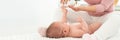 Baby massage banner with copy space. Kids therapist applying massage oil to baby boy. Mother massaging her newborn baby.