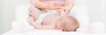 Baby massage banner with copy space. Kids therapist applying massage oil to baby boy. Mother massaging her newborn baby. Royalty Free Stock Photo