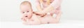 Baby massage banner. Young therapist giving a baby boy a back massage. Baby massage concept on white background with copy space.