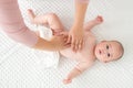 Baby massage. Female therapist gently massaging newborn baby boy. Mother applying body lotion to her infant baby boy. Royalty Free Stock Photo