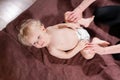 Baby massage. Mother or therapist makes massage to her baby at home. Health care and medicine concept. Blond boy Royalty Free Stock Photo