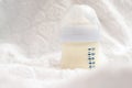 Baby milk formula in small bottle on white fluffy background Royalty Free Stock Photo