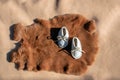 Baby moccasins displayed on a rabbit pelt and leather.