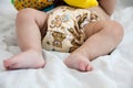 Baby in modern eco stacks of cloth diapers and replacement bushings selective focus close-up on bright background, little cute foo Royalty Free Stock Photo