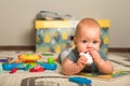 Baby 7 months old baby crawls and plays on floor with toys. Newborn care concept, teething, colic