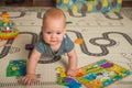 Baby 7 months old baby crawls and plays on floor with toys. Newborn care concept, teething, colic