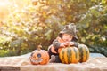 Baby 7 months old and harvest pumpkin close-up and copy space. Child in pumpkin costume for Halloween