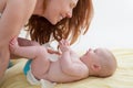 Baby with mother diapering and playing smiling Royalty Free Stock Photo