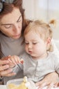 Baby with mother eating from tupperware