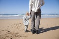 Baby and mother holding hands next to ocean Royalty Free Stock Photo