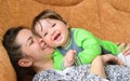 Baby with mother laugh. real emotions. Happy family. baby and mother play, kiss, tickle, laugh in bed. Happy family. baby and Royalty Free Stock Photo