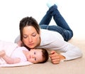 Baby and mother lying on beige carpet together Royalty Free Stock Photo