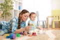 Baby and mother playing toy rings. Toddler kid plays pyramid, children early education
