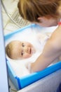 Baby, mother or smile in bathtub for shower, cleaning and hygiene with foam or bubbles for enjoyment. Child, woman or