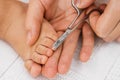 Baby nail cut. Hand with scissors trims toenails of a sleeping baby. Selective focus Royalty Free Stock Photo