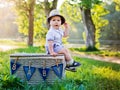 Baby on the nature sits a basket