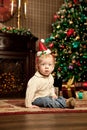 Baby near the Christmas tree. Little boy celebrati