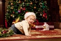 Baby near the Christmas tree. Little boy celebrati