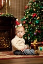 Baby near the Christmas tree. Little boy celebrati