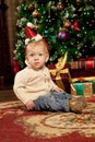 Baby near the Christmas tree. Little boy celebrati