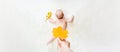 Baby newborn child banner. Mother hand holding yellow leaf. Happy cute baby kid girl lying on white bed background. Cute Royalty Free Stock Photo