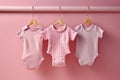 Baby newborn girl pink bodysuits on a line on pink background. Laundry day, baby clothes, baby shower theme, it\'s a girl Royalty Free Stock Photo