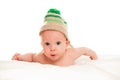 Baby newborn lying on her stomach on the bed in a funny knitted hat isolated on white background, the concept of choosing baby clo Royalty Free Stock Photo