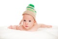 Baby newborn lying on her stomach on the bed in a funny knitted hat isolated on white background, the concept of choosing baby clo Royalty Free Stock Photo