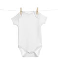 Baby onesie hanging on clothes line against white background