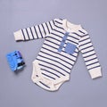 Baby onsie and toy over blue background Royalty Free Stock Photo