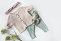 Baby organic knitted clothes top view. Soft pastel colors infant clothing flat lay on white