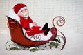 Baby with pacifier in Christmas sleigh