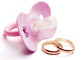 Baby pacifier and wedding rings, conceptual