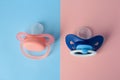 Baby pacifiers on color background, above view