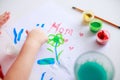 Baby painting picture with fingers or brush for mother