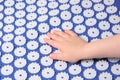 Baby palm on a blue massage acupuncture mat with white massage tips