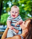 Baby in park outdoor. Kid on mom`s hands. Royalty Free Stock Photo