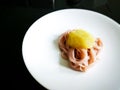 A baby handthe baby pasta served with fruits and vegetables puree on a white plate. An organic homemade food for the baby. Royalty Free Stock Photo