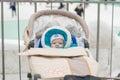 Baby in a perambulator baby carriage at a winter day Royalty Free Stock Photo