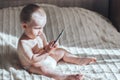 Baby with the phone sitting on bed Royalty Free Stock Photo