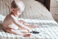 Baby with the phone sitting on bed Royalty Free Stock Photo