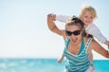 Baby piggybacking mother on beach Royalty Free Stock Photo