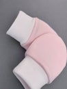 Baby pink scratch mittens on grey background Royalty Free Stock Photo