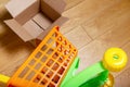 Baby plastic shopping trolley and empty cardboard box on the floor