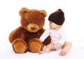 Baby playing with big teddy bear toy on white Royalty Free Stock Photo