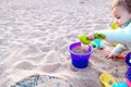 Baby playing with buckets and plastic toy shovels in a sandbox Royalty Free Stock Photo