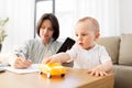 Baby playing with car and mother working at home Royalty Free Stock Photo